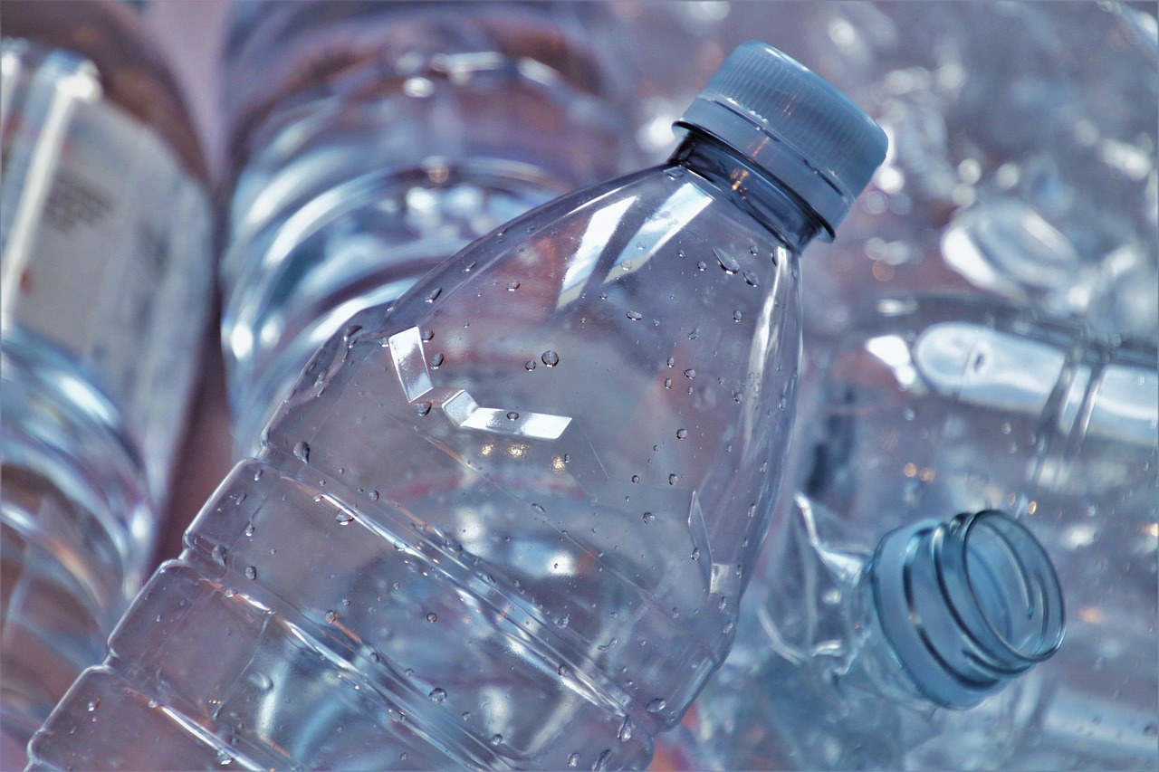 A close-up of several empty clear plastic water bottles, representing plastic waste.