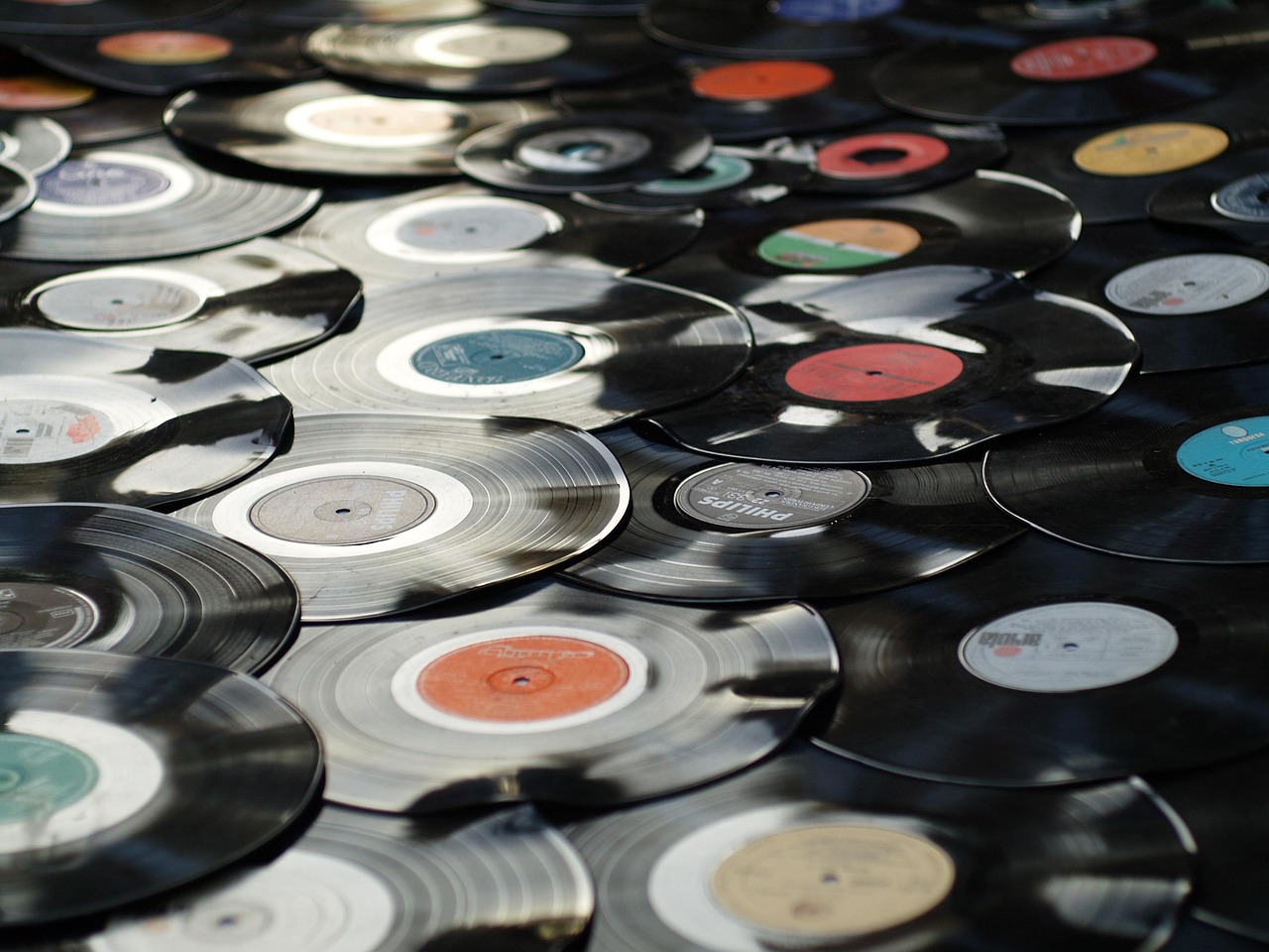 A collection of vintage vinyl records spread out, showing their circular shape and center labels.